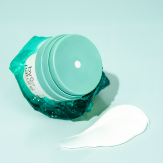 All Day duo moisturizer posed with jelly, next to a swatch of moisturizer on green background.