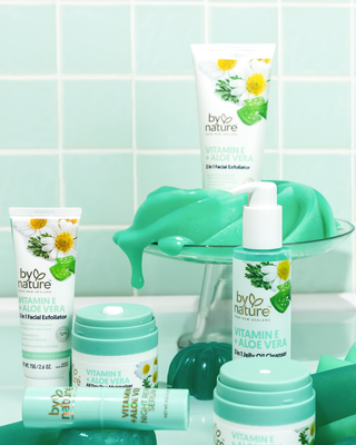 Collection of By Nature skincare products on a light green tiled background with jelly on background