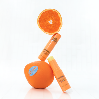 Vitamin C Serum sticks Orange-themed skincare products with a sliced orange on a white background